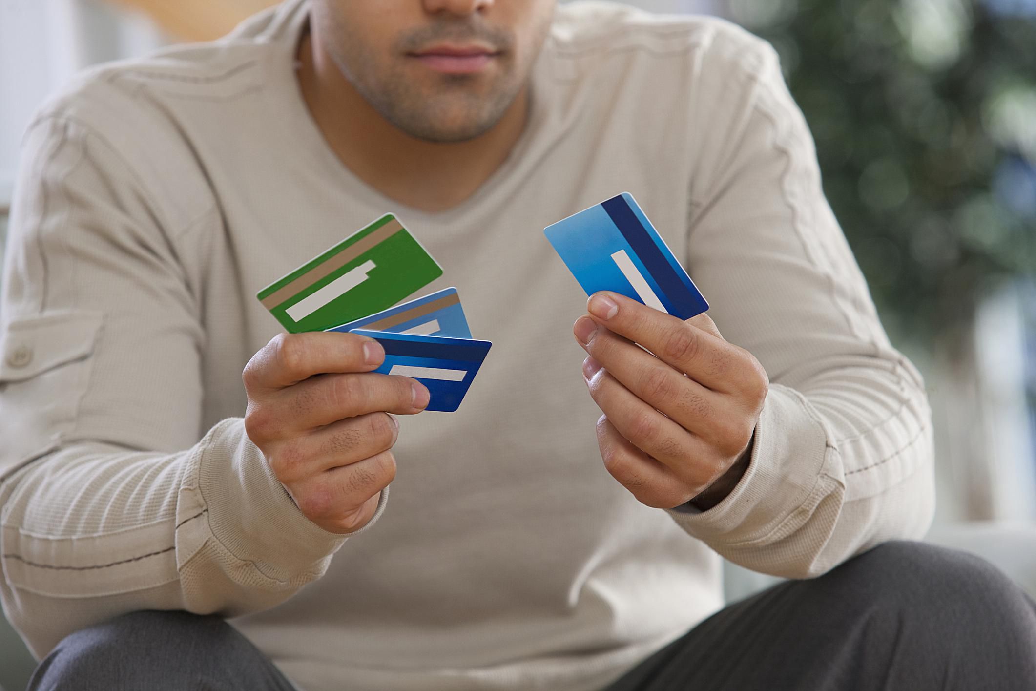 Bank debt. Мужчина с кредиткой. Карточка человека. Мужчина с картой банка. Много банковских карт в руке.