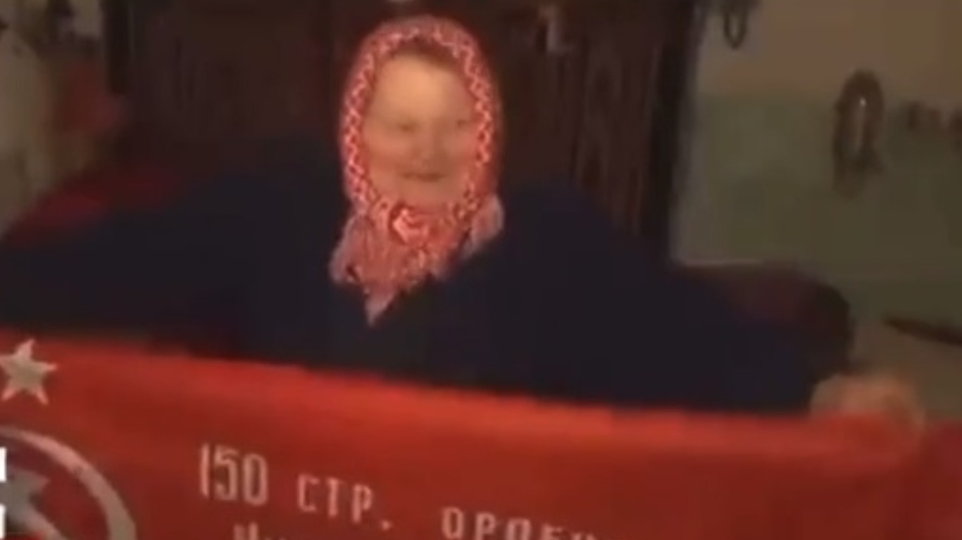 Бабушка с украины жива. Бабулька с флагом. Бабуся с красным флагом. Бабуля с флагом на Украине. Плакат бабушка с красным флагом.