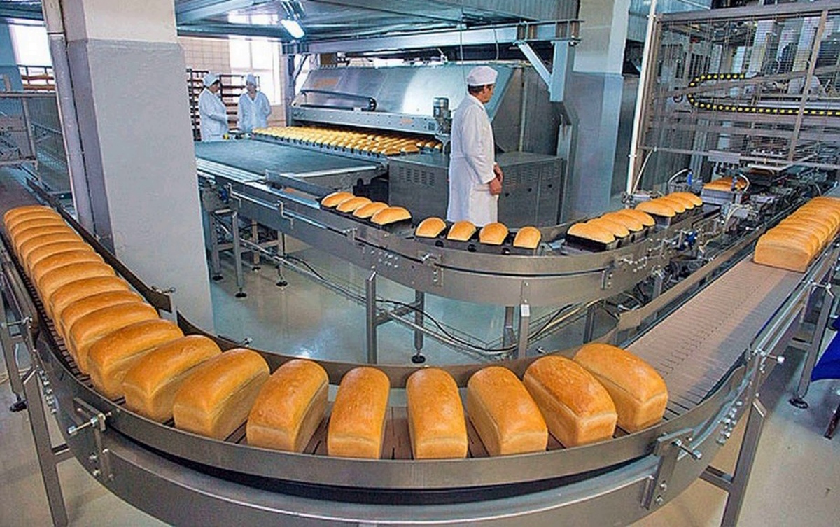 Хлеб цех. Хлеб на конвейере. Цех хлебобулочных изделий. Производственная линия хлеба. Хлебобулочная промышленность.
