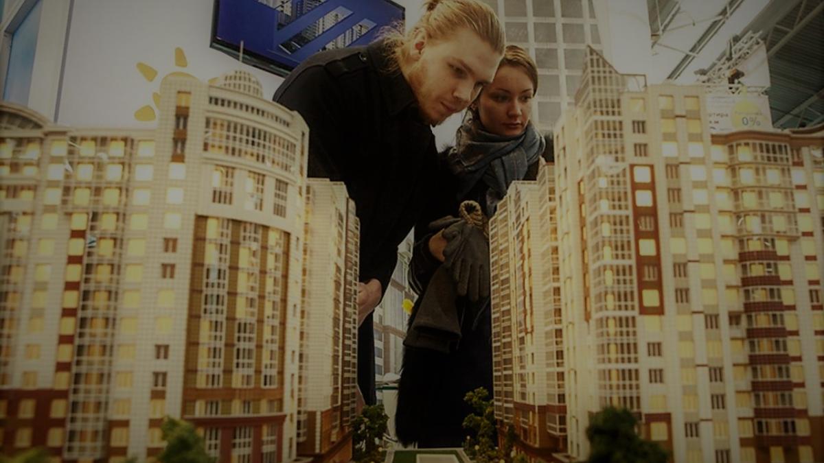 мужчина и женщина рассматривают макет дома ипотека