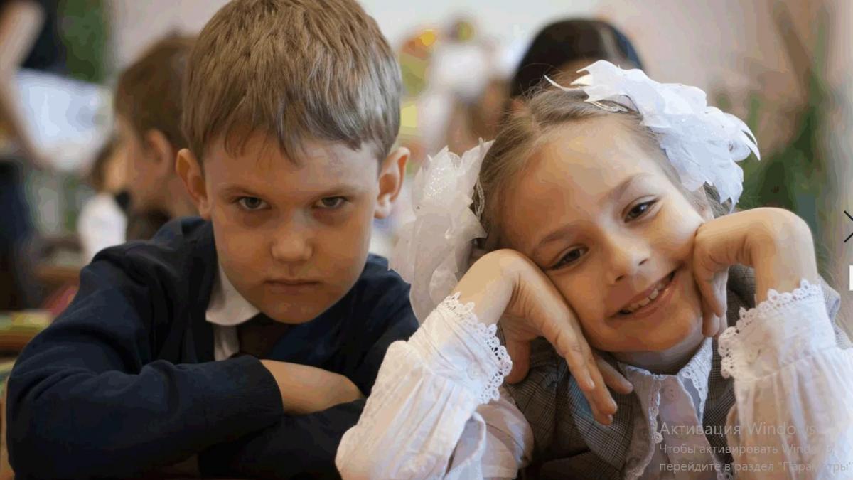 Фото первоклассников за партой: слева нахмуренный мальчика и справа улыбающаяся девочка Мальчик и девочка первоклассники