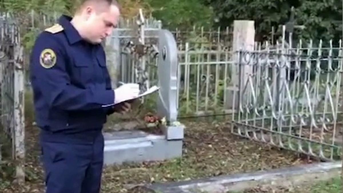Сотрудник СК во время следственного действия на кладбище Следователь