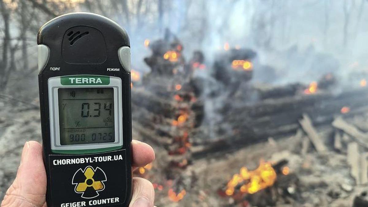 Лесные пожары в Чернобыльской зоне повысили уровень радиации человек измеряет уровень радиации