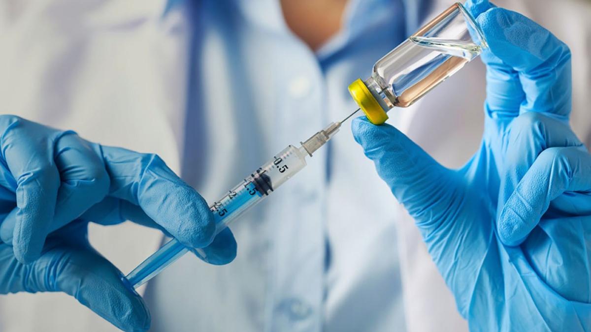 Врач наполняет шприц вакциной вакцинация